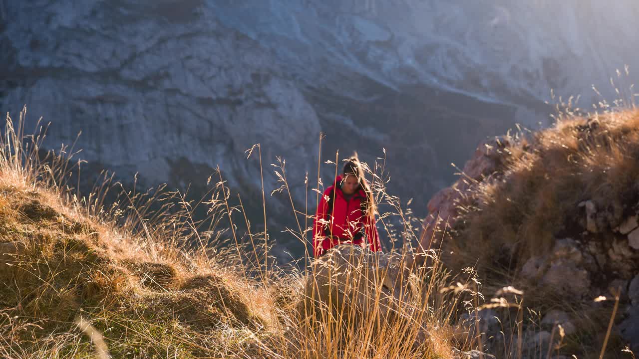 健康的女人征服了山路，周围是令人敬畏的高山景观视频素材