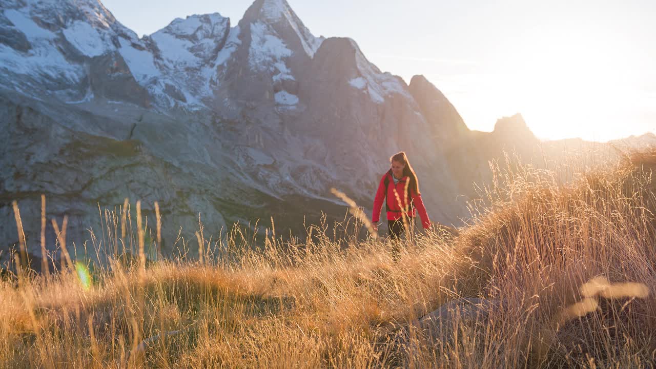 爱冒险的女人探索自然，在风景如画的山区徒步旅行视频素材