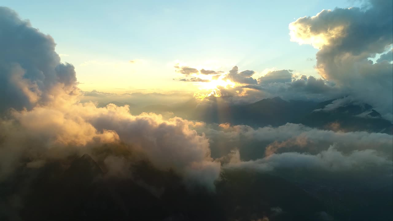 天上的日落越过高山链。黄昏时梦幻般的高空云景。雄伟的黄金时刻越过崎岖的山峰。视频素材