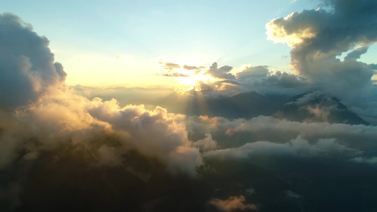 天上的日落越过高山链。黄昏时梦幻般的高空云景。雄伟的黄金时刻越过崎岖的山峰。视频素材