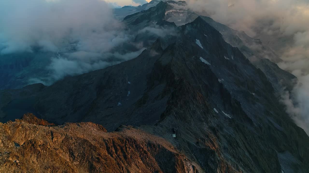 黄昏时分，落基山脉的山顶景色如画。飞越崎岖的高山峰顶。梦幻般的云景在悬崖顶上旅行。从上面俯瞰阿尔卑斯山的壮丽景色。视频素材