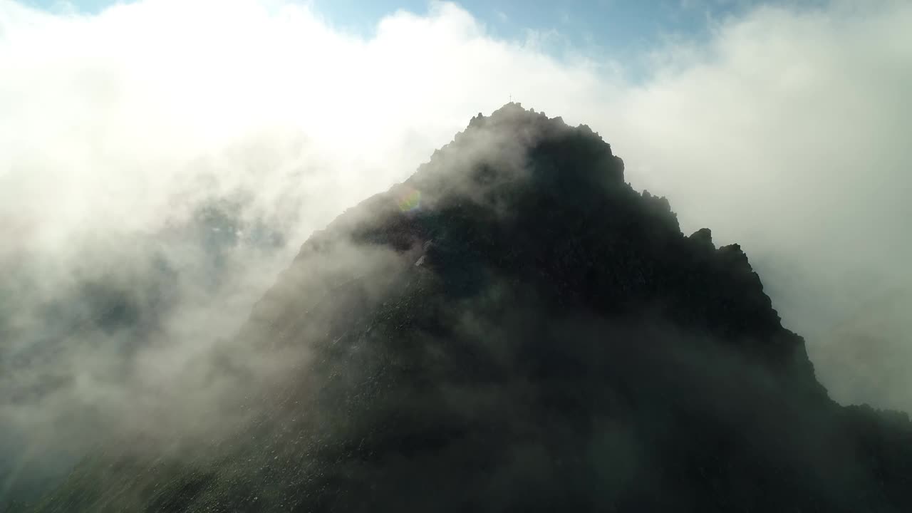 空中无人机拍摄的天山高峰。云雾在崎岖的高山峭壁上飘动。引人注目的高山风光峰顶。视频素材