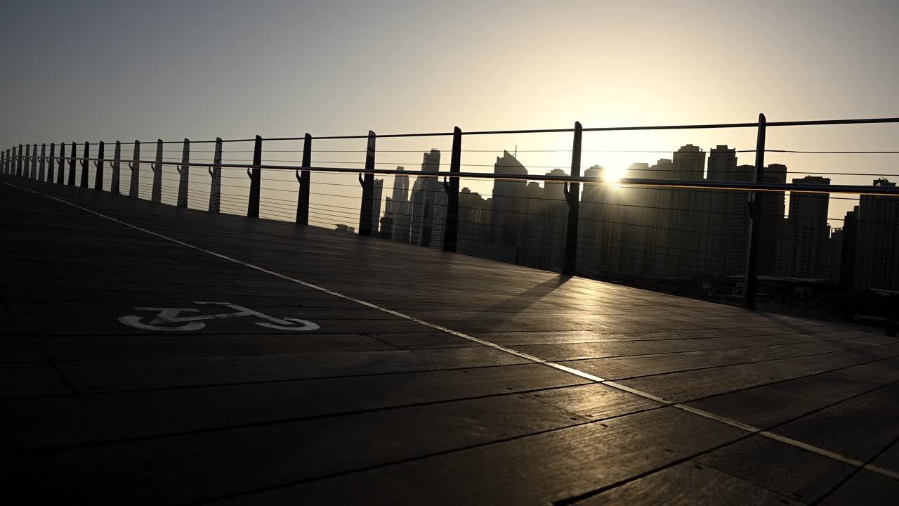 太阳落在迪拜城市的天际线上，在城市景观上投射出温暖的光芒视频素材