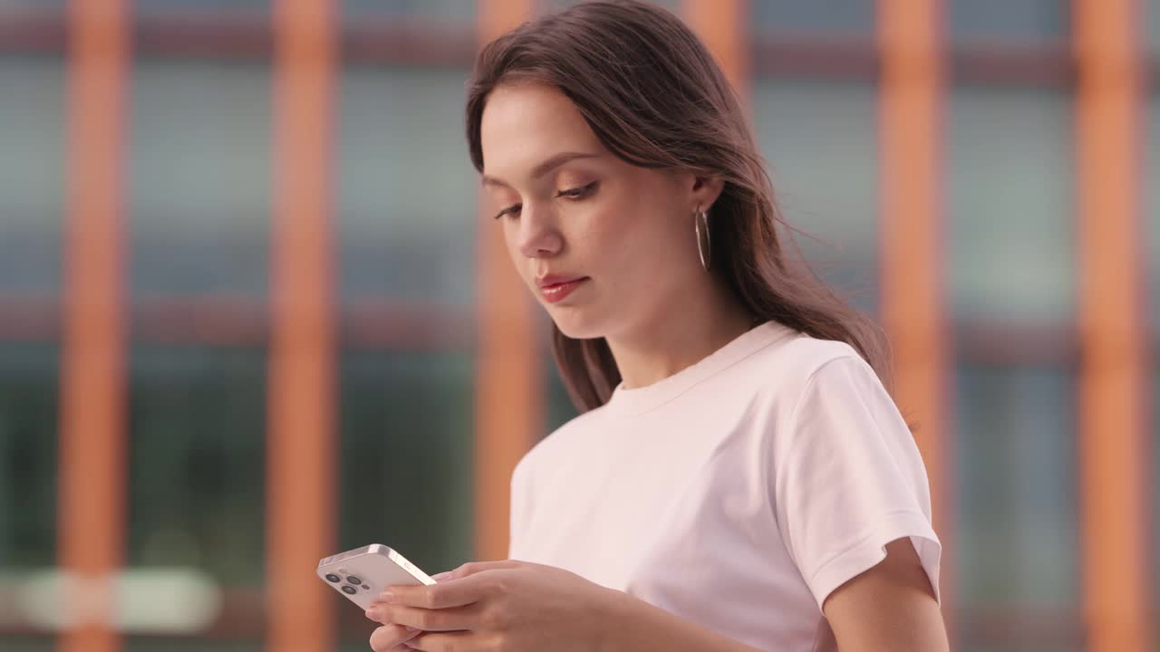 年轻女子在户外等待时查看手机视频素材