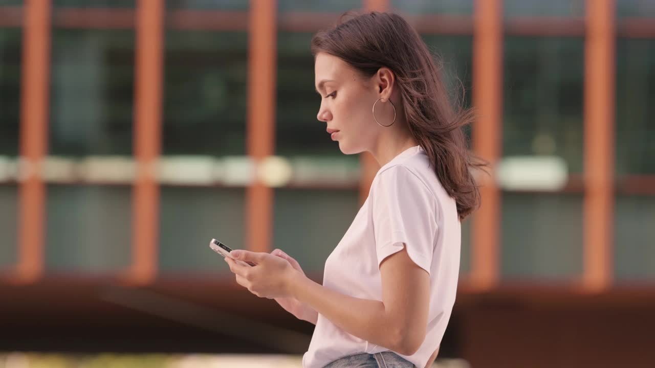 黑发女人在城市里查看智能手机视频素材