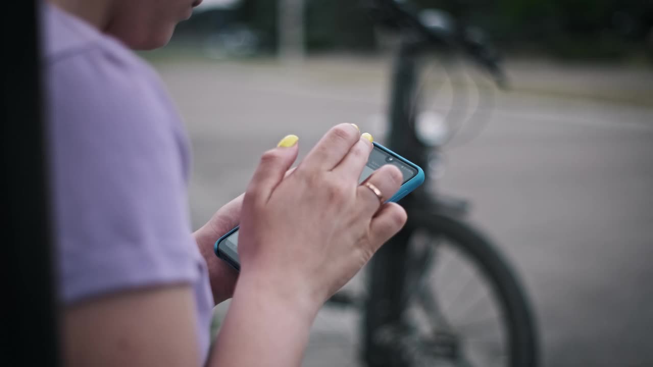 女性骑自行车使用智能手机视频下载