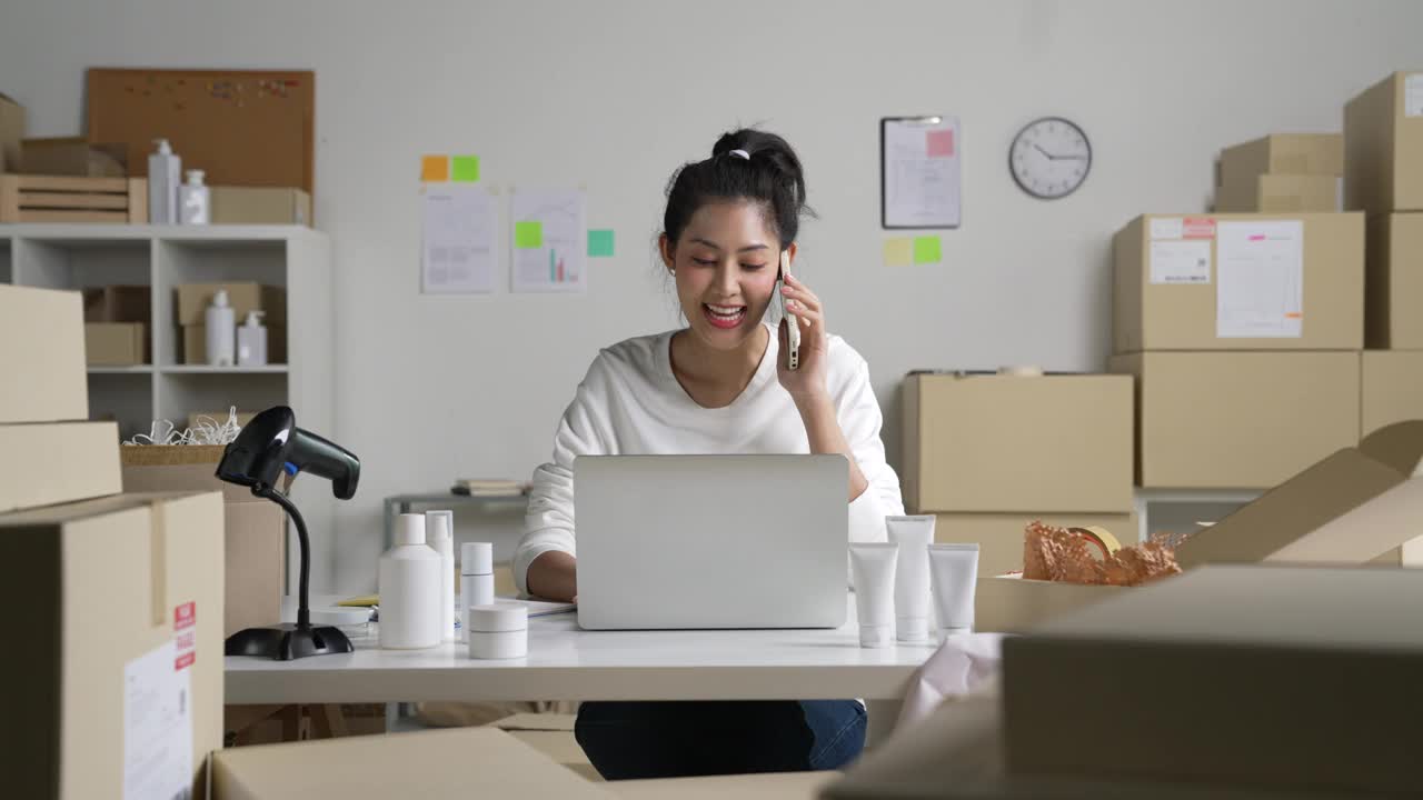 亚洲女卖家在电话中确认客户的订单。在仓库工作的电子商务企业主。视频下载