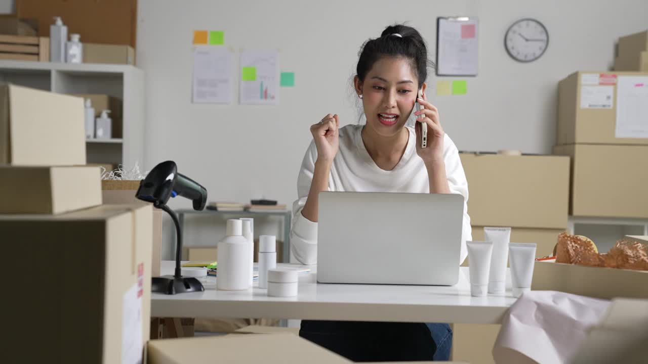 亚洲女卖家在电话中确认客户的订单。在仓库工作的电子商务企业主。视频下载