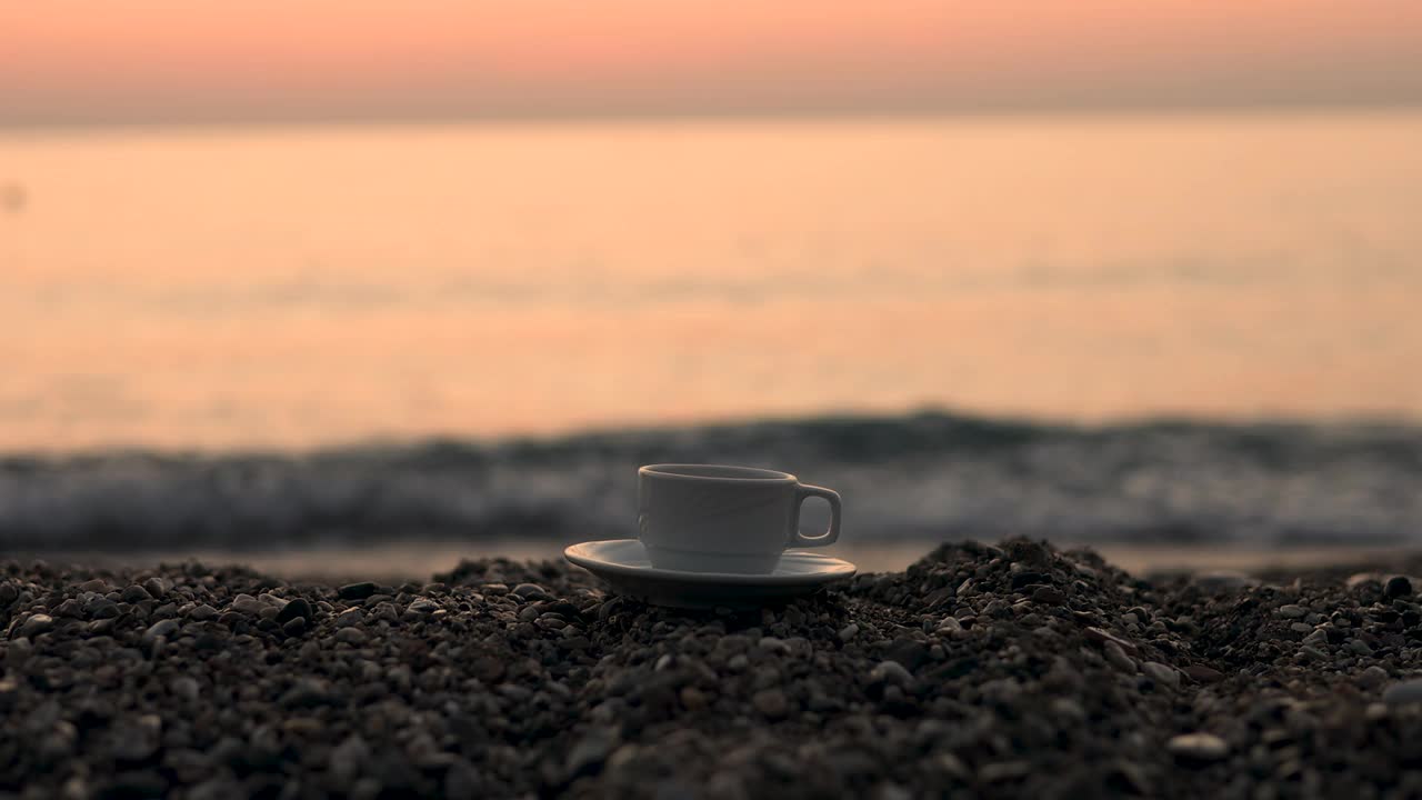 海水和沙滩，日出或日落的时间。在海浪中喝杯茶或咖啡视频下载