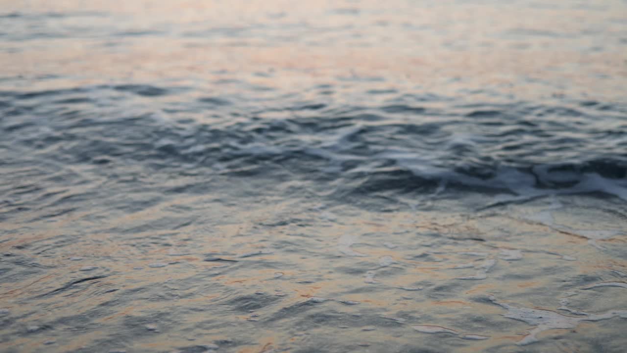 海水和沙滩，日出或日落的时间。在海浪中喝杯茶或咖啡视频素材