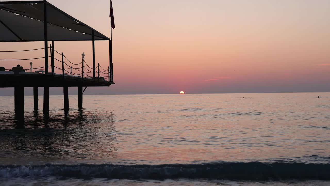 海水和沙滩，日出或日落的时间。在海浪中喝杯茶或咖啡视频素材