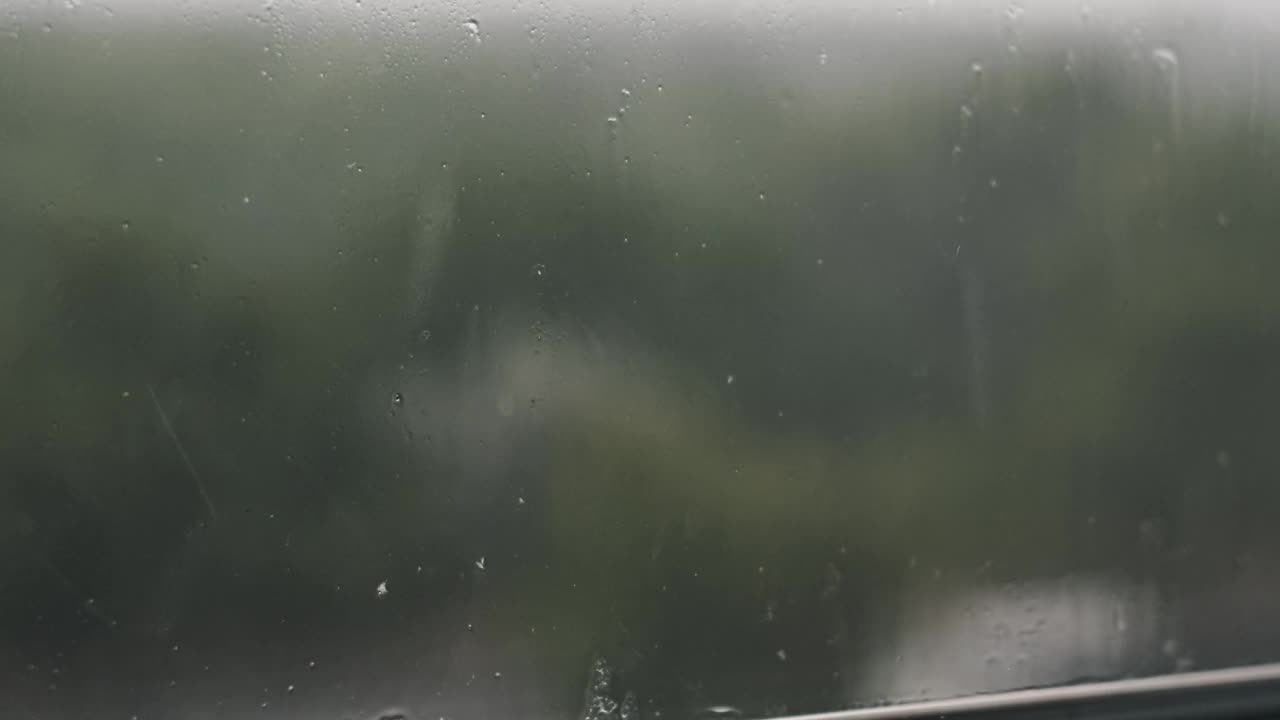 雨落在窗户上——绿色的景色视频素材