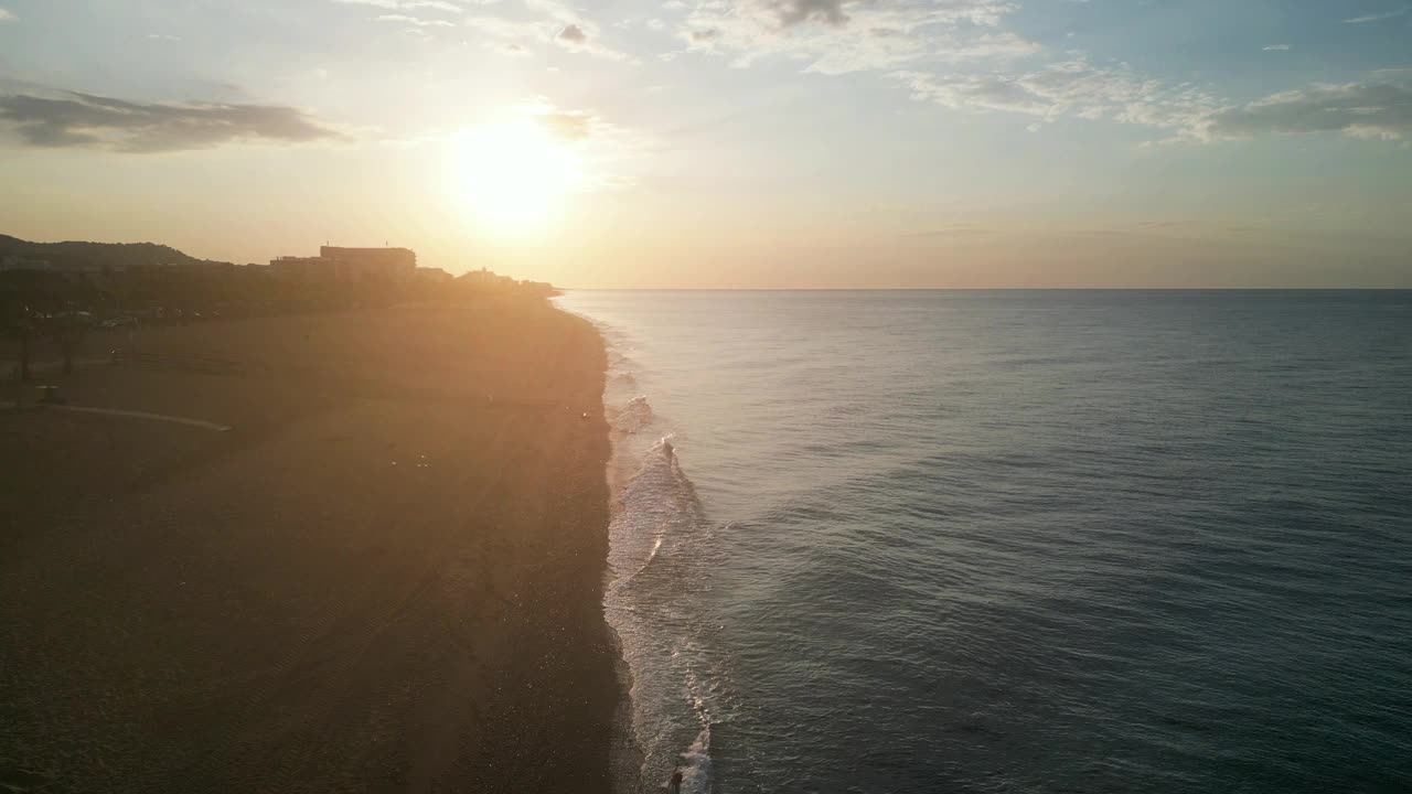 美丽的空中海景和女人在日出时空旷的海滩上，4K视频素材