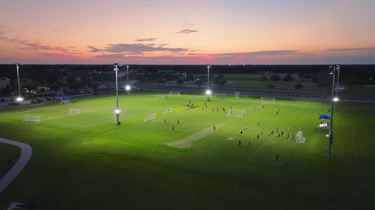 晚上有年轻人在公共体育场踢足球。积极的生活方式理念视频素材