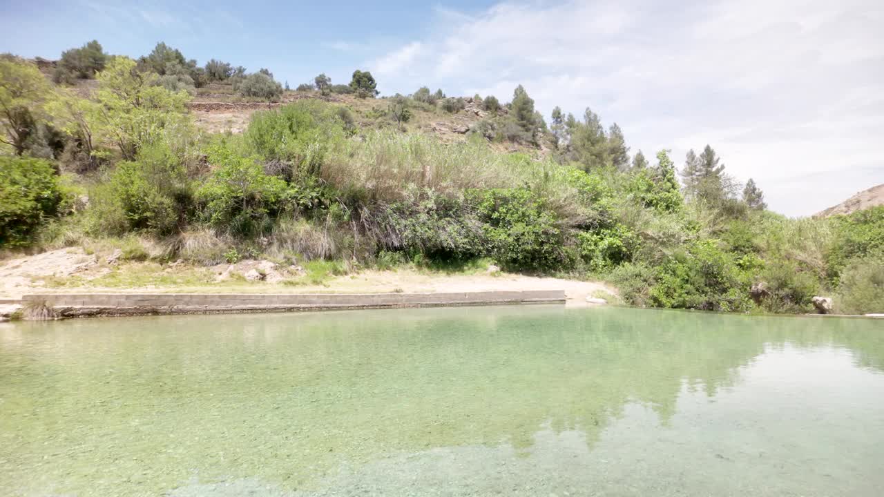 一个美丽的湖泊，背后是一座绿色的小山视频素材