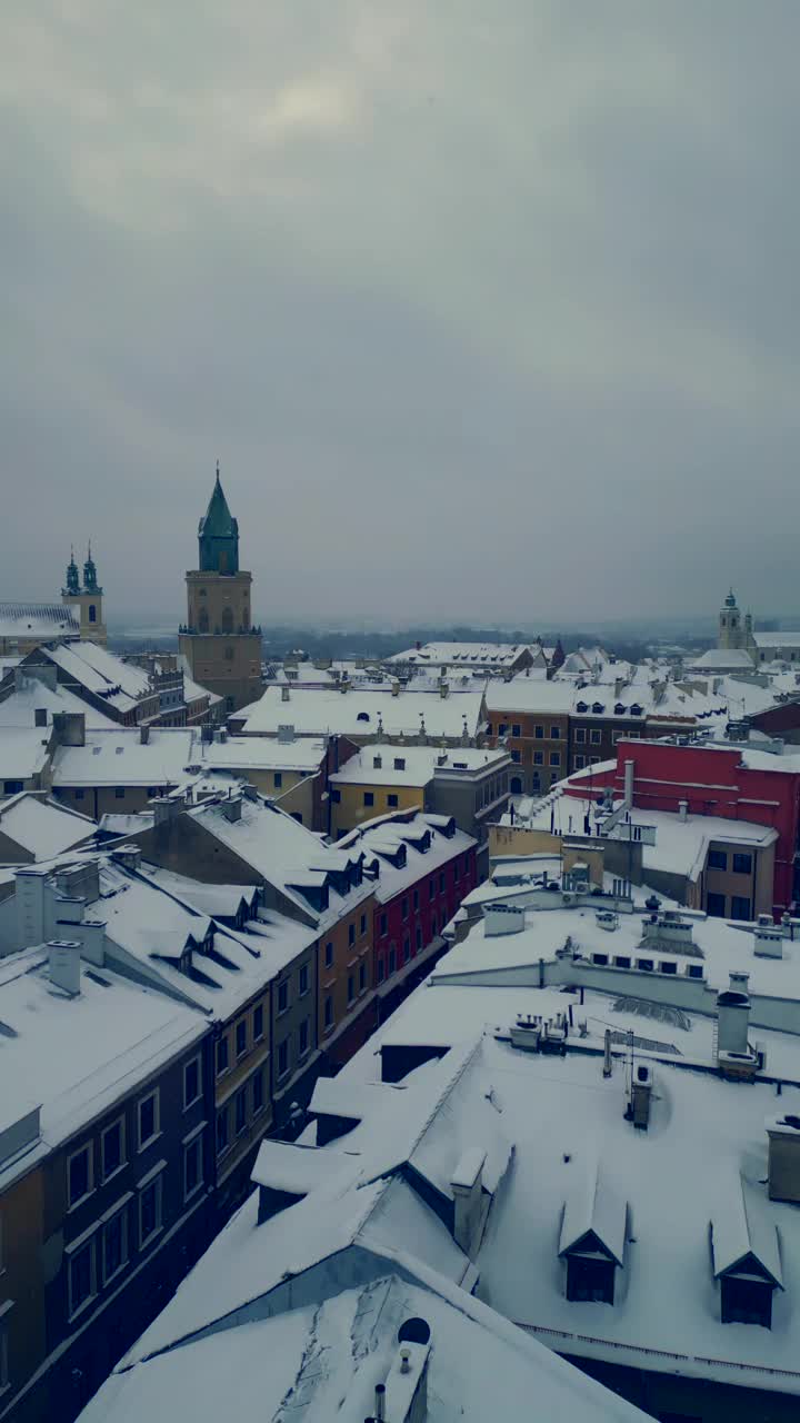 欧洲古城卢布林的白雪皑皑的冬天，波兰古地区屋顶上的暴风雪和降雪，欧洲4k视频素材