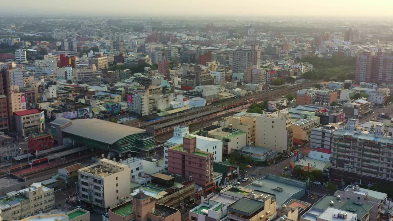 台湾云林县斗流市，无人机在市中心拍摄的城市景观和日落时火车离开火车站的鸟瞰图。视频素材