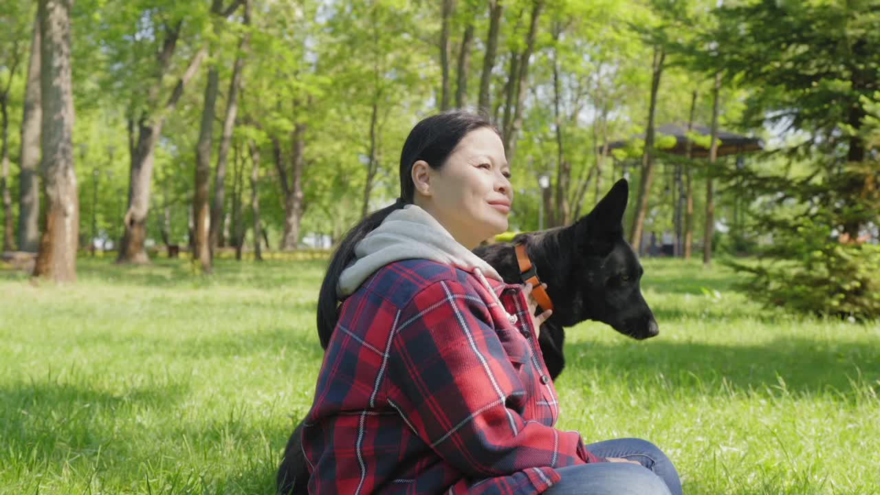 爱犬女主人带着爱犬，享受夏日的悠闲风光视频素材