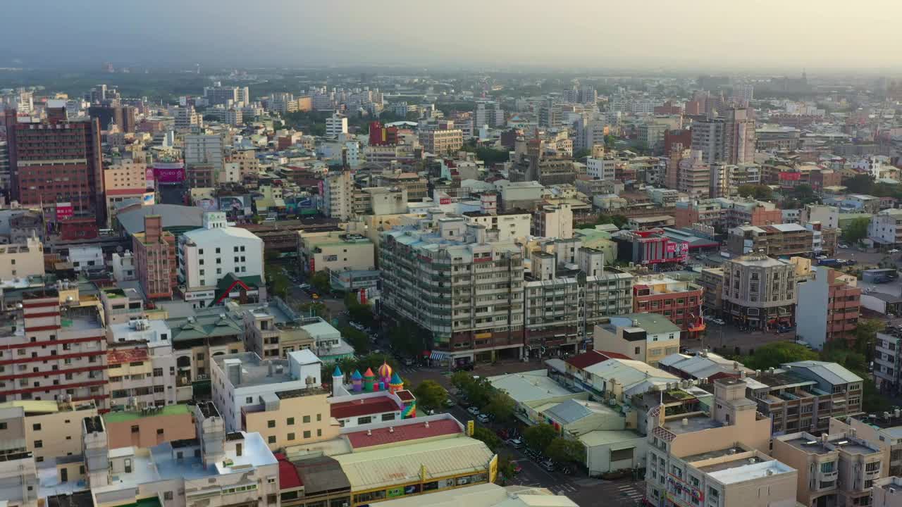 鸟瞰图，无人机在城市上空飞行，捕捉市中心的城市景观，日落时分，火车到达台湾云林县斗流总站。视频素材