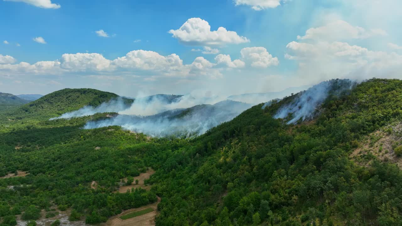 航拍:在阳光明媚的南欧山区，烟雾缭氲的山丘和燃烧的森林视频素材