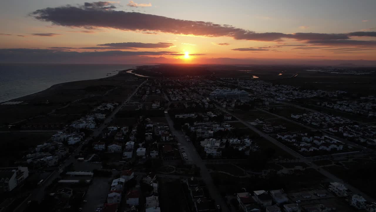 夕阳西下，在度假小镇上空向着大海。视频下载