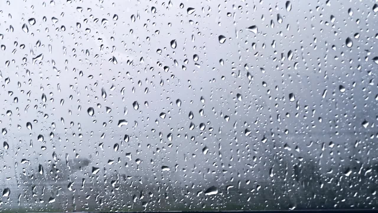 大雨中水滴在窗户玻璃上的镜头。视频素材