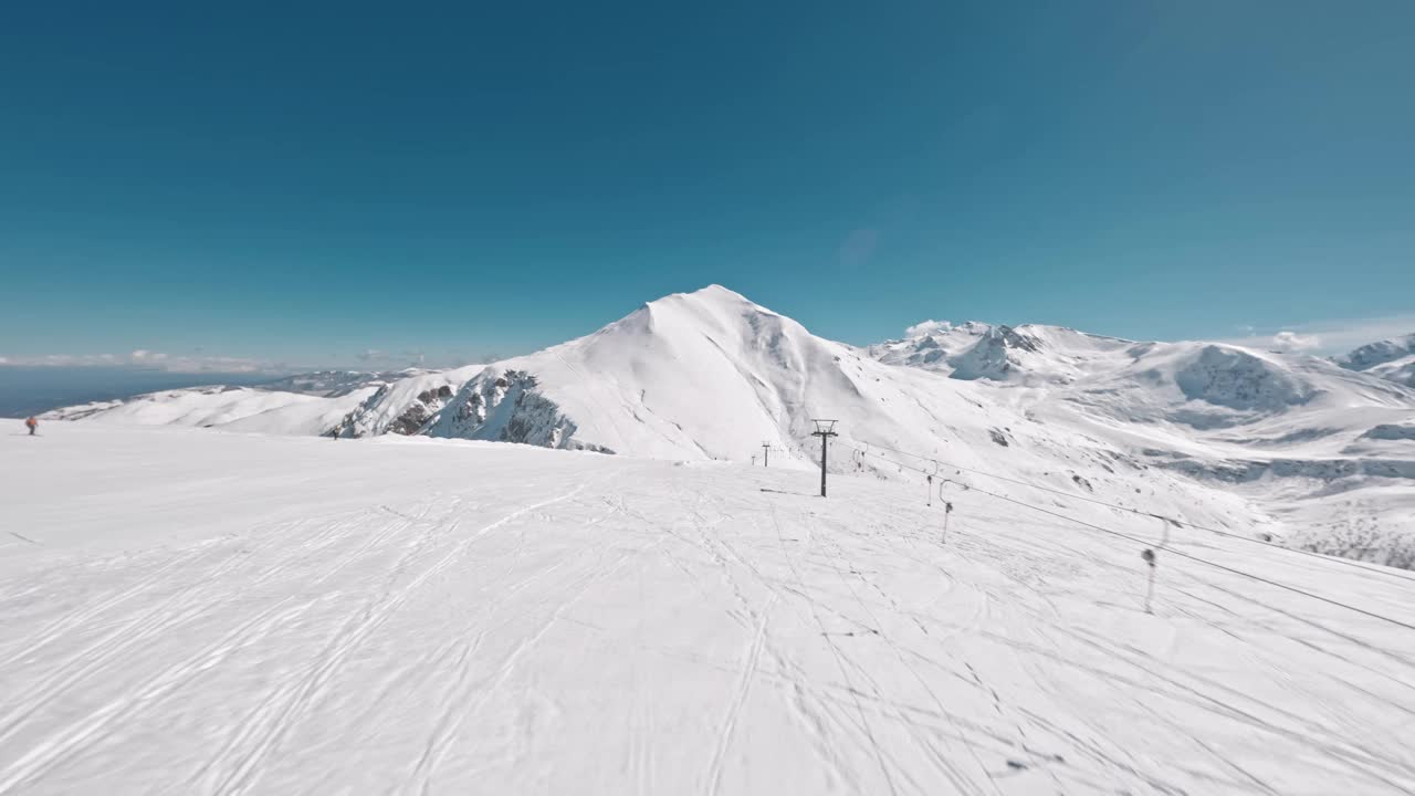 雪山峰顶有滑雪缆车，天空碧蓝，鸟瞰视频素材