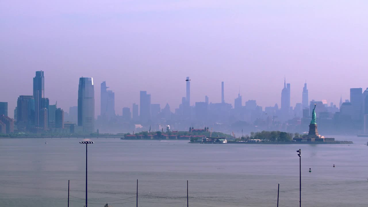 纽约市的风景和一架直升机飞过城市和雕像视频下载