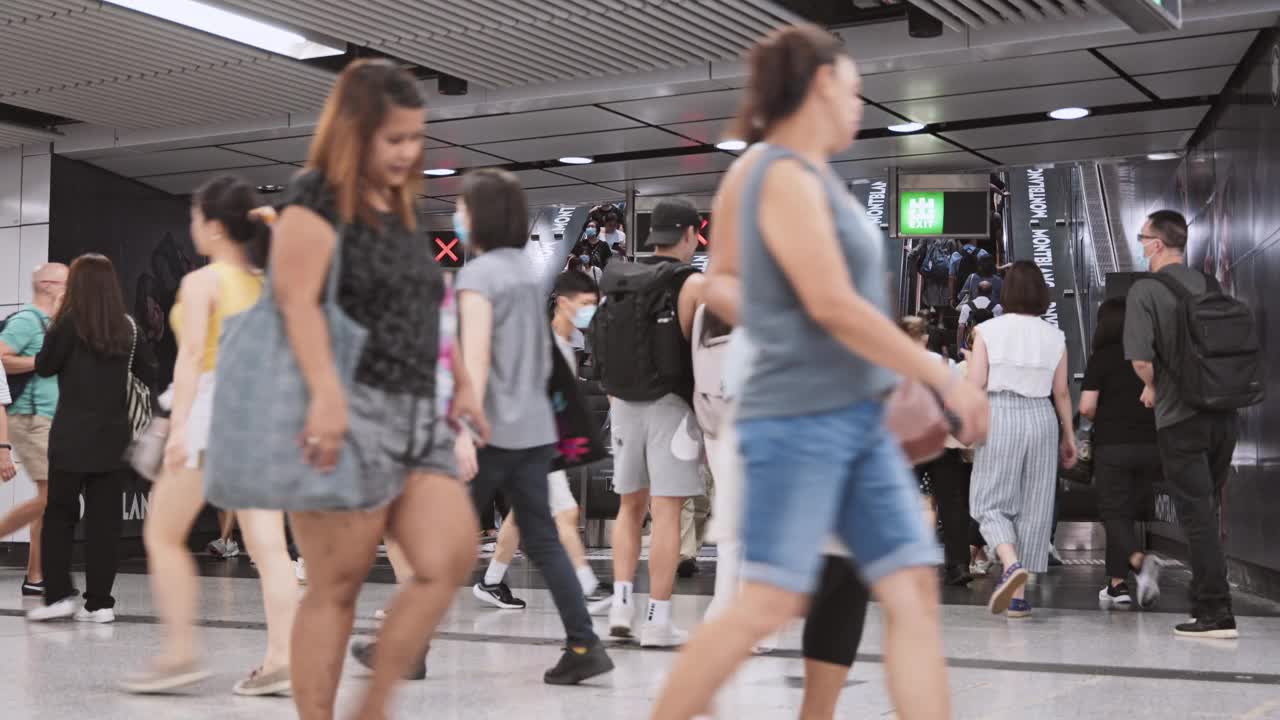 在香港中环地铁站，一群亚洲人、游客和旅客在使用自动扶梯。公共交通，亚洲城市生活，或通勤城市生活方式概念视频下载