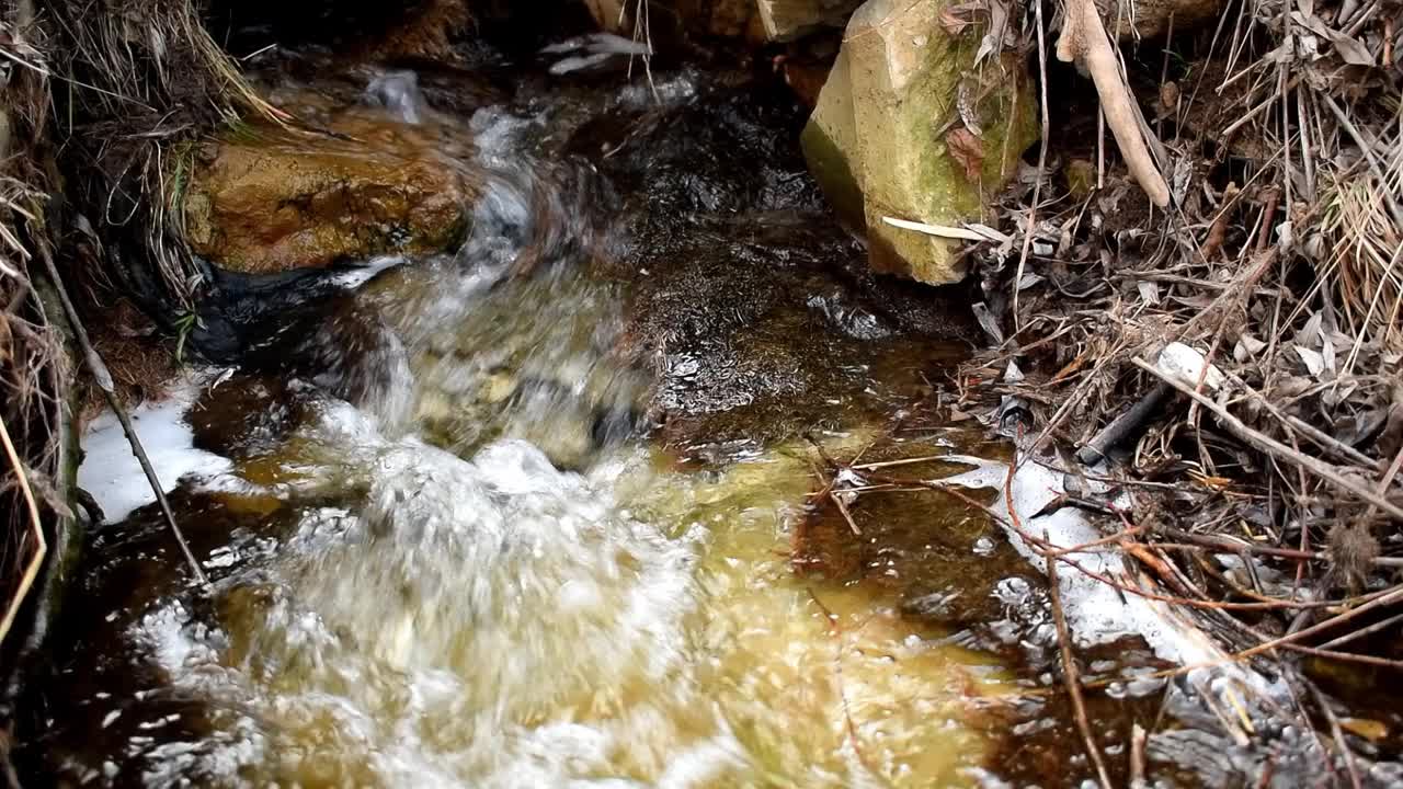 小溪在春天流动。山里河里的污水。污水、处理设施。环境污染，生态。城市工业废弃物污染视频下载