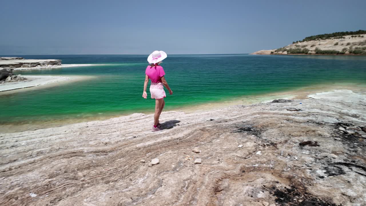 年轻女子正在享受风景优美的海滨散步视频素材