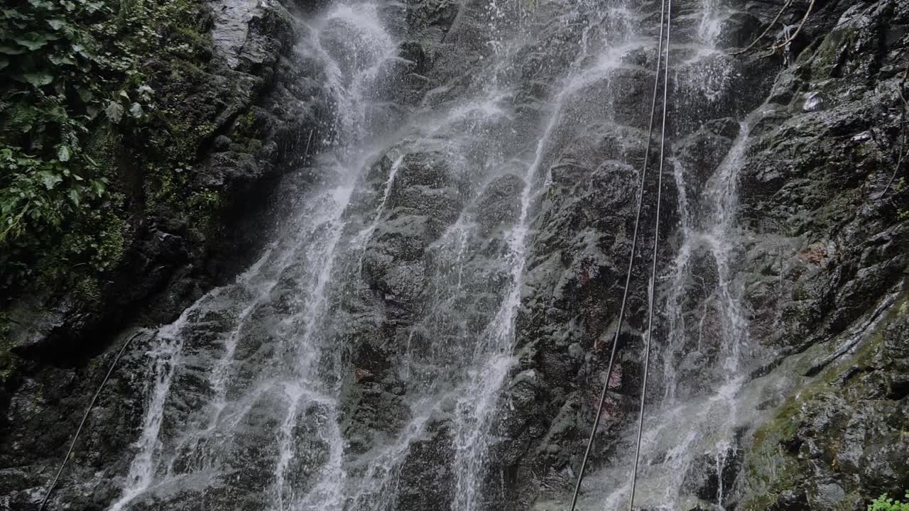 瀑布在山、河或小溪中流动和落下:慢动作视频素材