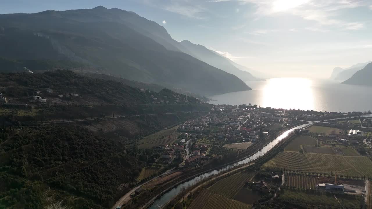 鸟瞰图里瓦德尔加尔达，意大利:一个风景如画的小镇依偎在山和水视频素材