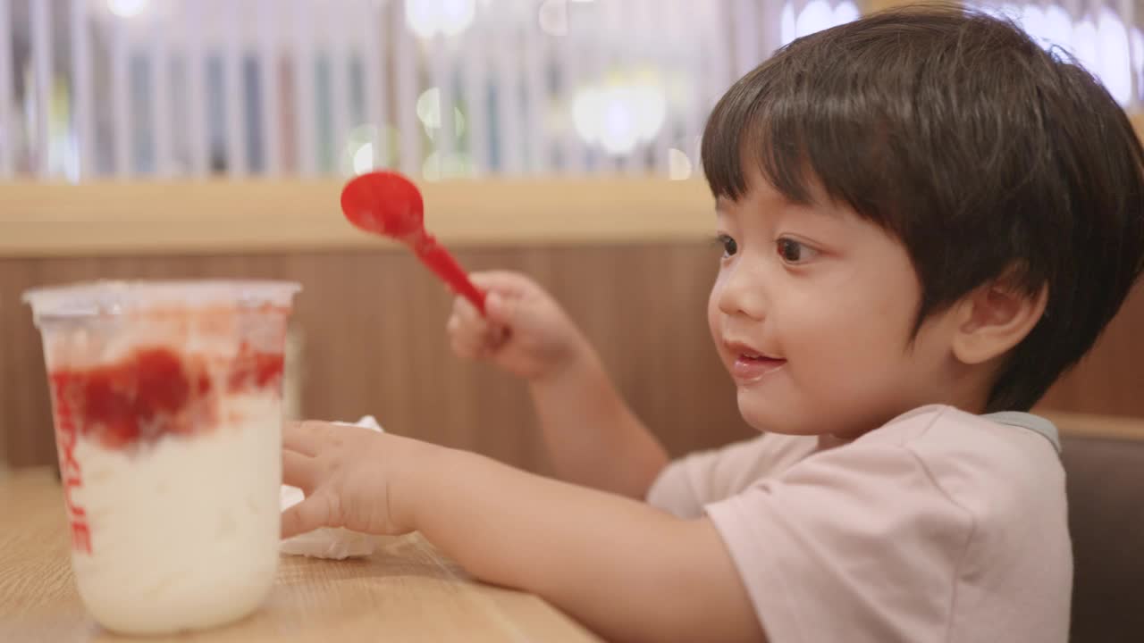 快乐的亚洲男孩喜欢吃冰淇淋。视频素材