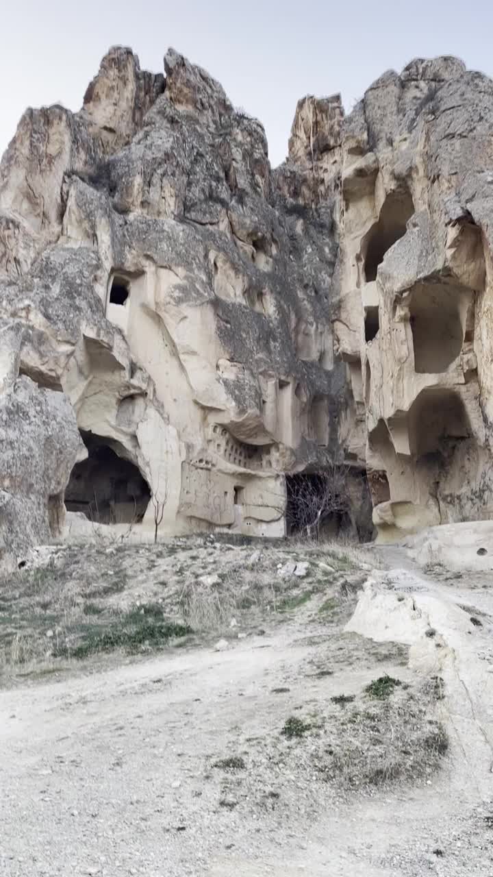 冬季，土耳其卡帕多西亚地区的女性在山间洞穴中行走视频下载