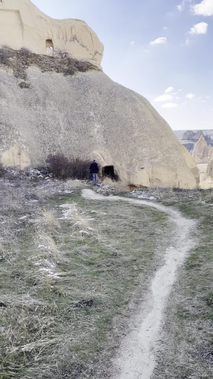 冬天，土耳其卡帕多西亚地区的男性在山间洞穴中行走视频下载