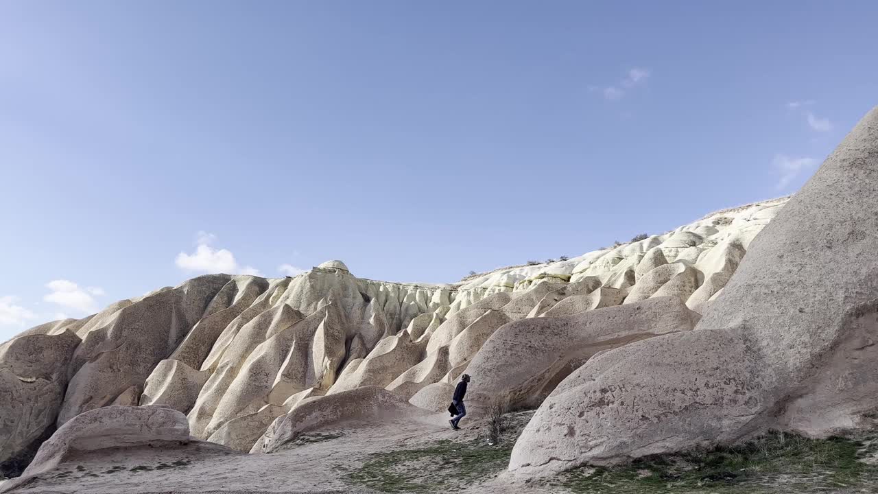 冬天，土耳其卡帕多西亚地区的男性在山间洞穴中行走视频下载