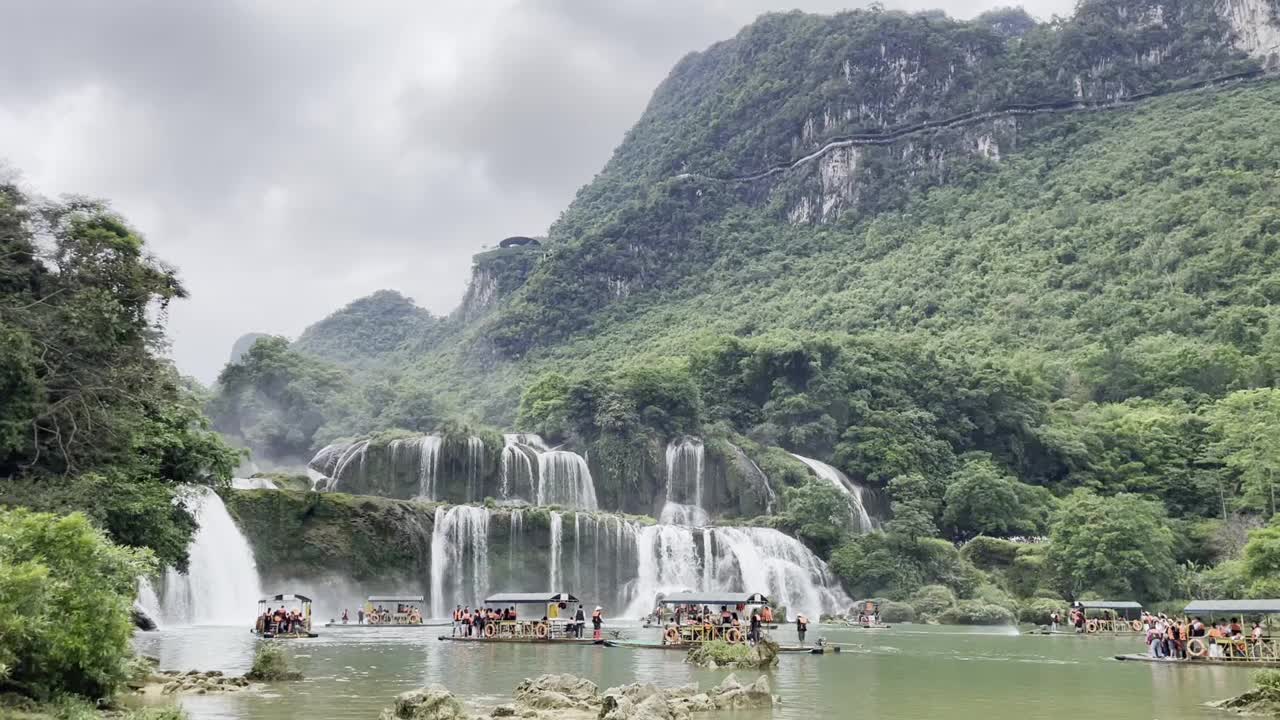 在越南丛林旁的瀑布河上与游客乘船视频下载