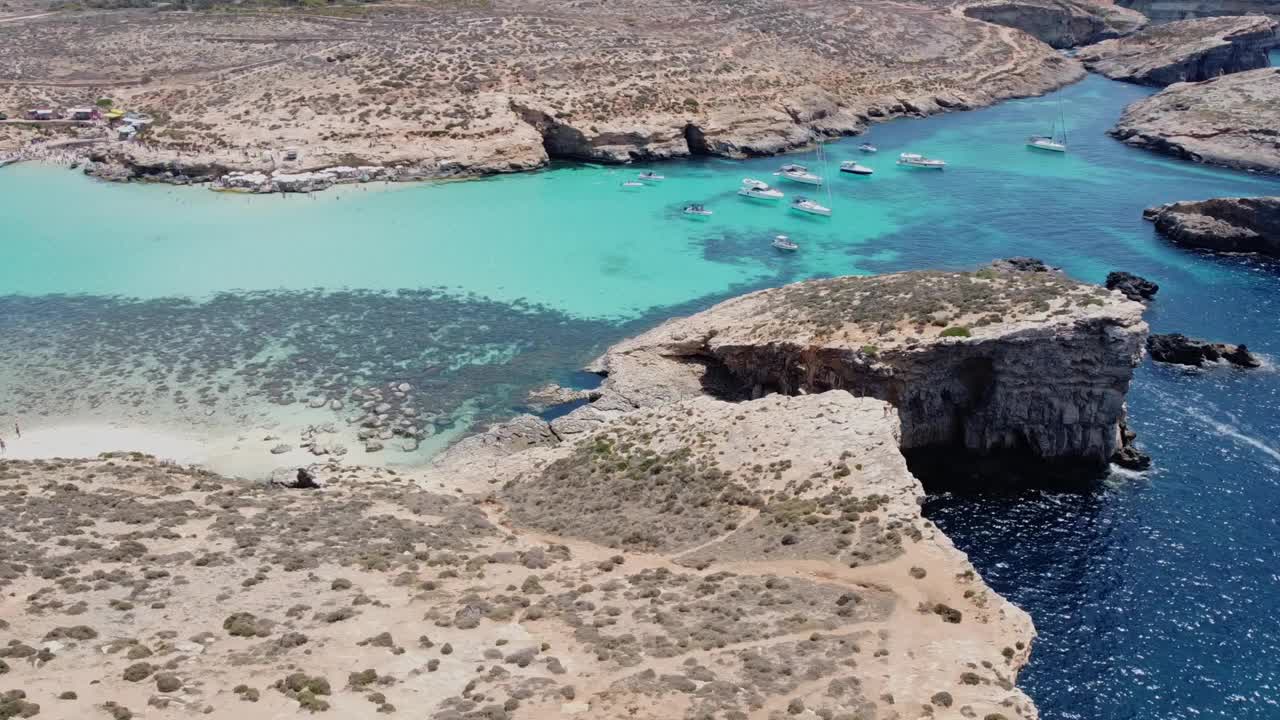 美丽的白色沙滩上无人居住的科米诺岛，和蓝色泻湖科米诺，马耳他。航空轨道拍摄视频下载