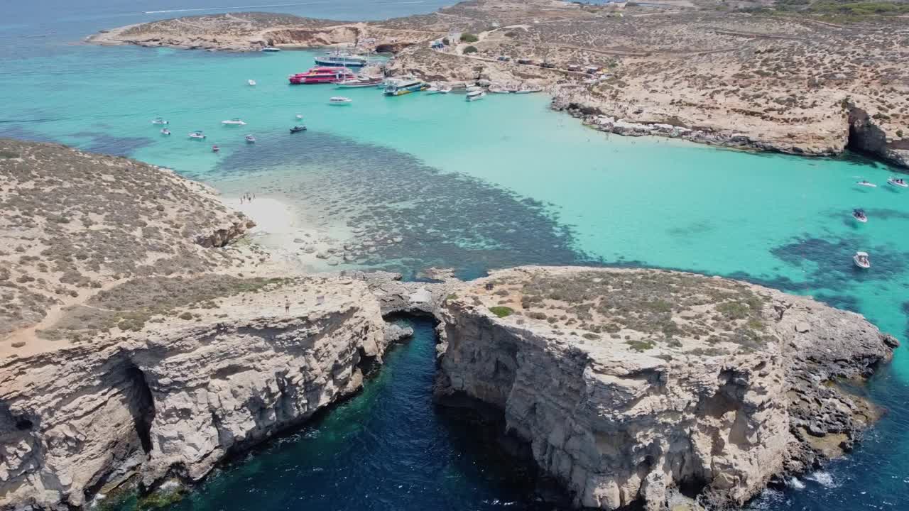 美丽的白色沙滩上无人居住的科米诺岛，和蓝色泻湖科米诺，马耳他。航空轨道拍摄视频下载