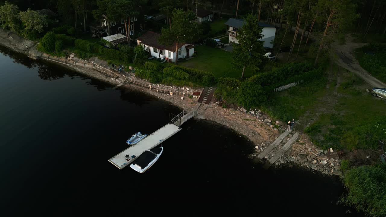 品尝一个宁静的夜晚在湖边小屋和码头在一个宁静的乡村环境夜幕降临视频素材