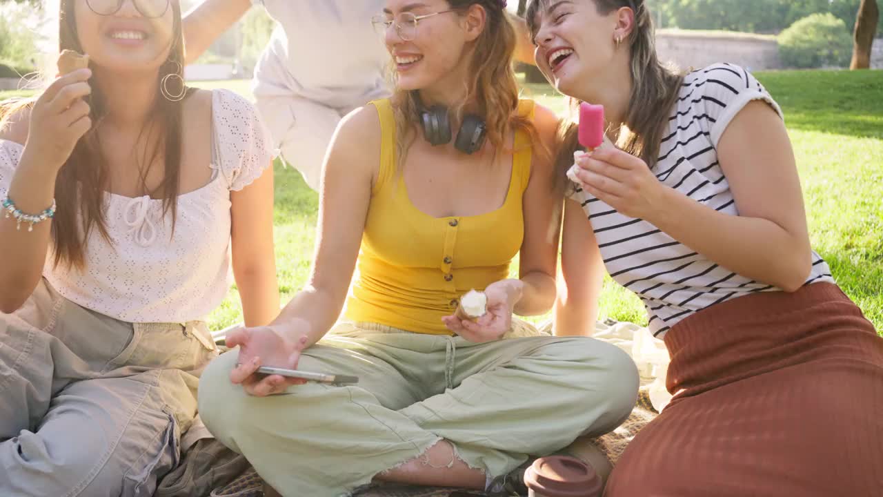 一群多种族的女性朋友在野餐时一边吃冰淇淋一边自拍视频素材