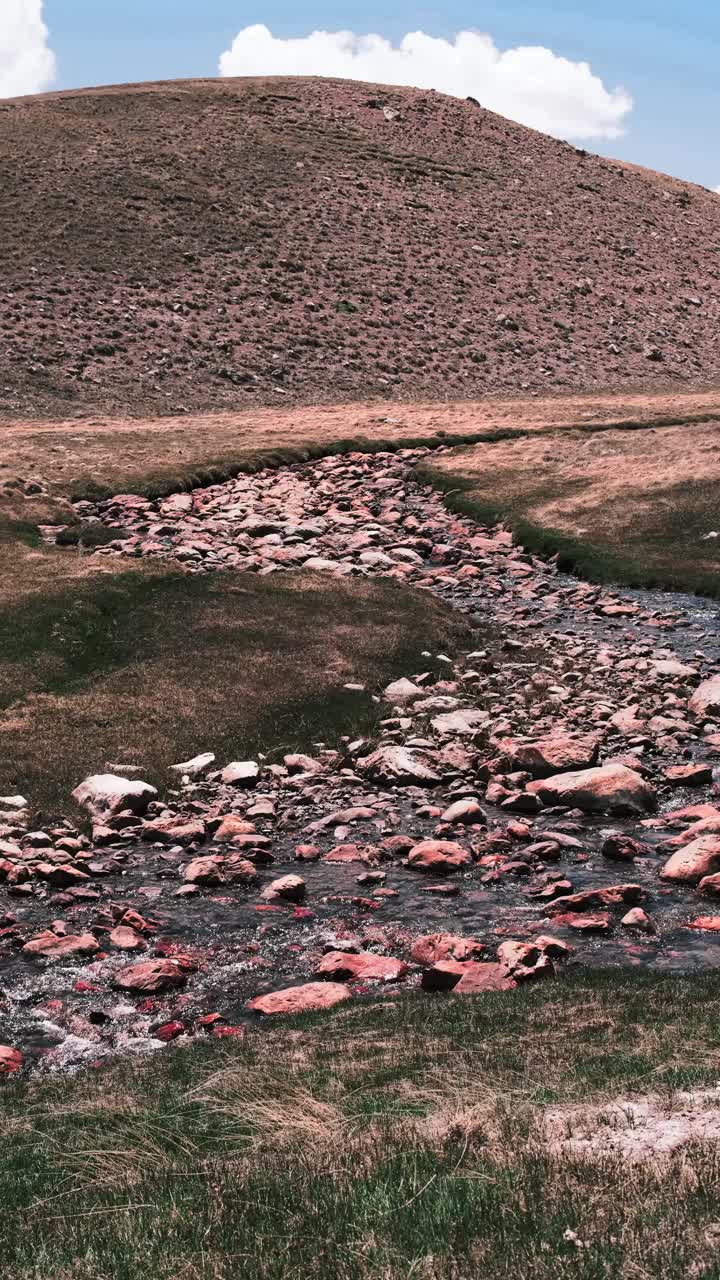 一条安静的小河流，在岩石河床上沿着山谷流动视频素材