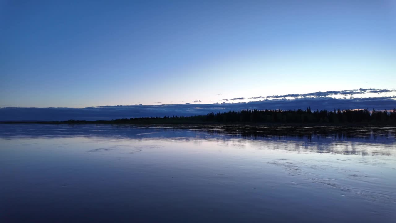 俄罗斯，黄昏时分，一条平静的河流映出美丽的天空和树木。视频素材