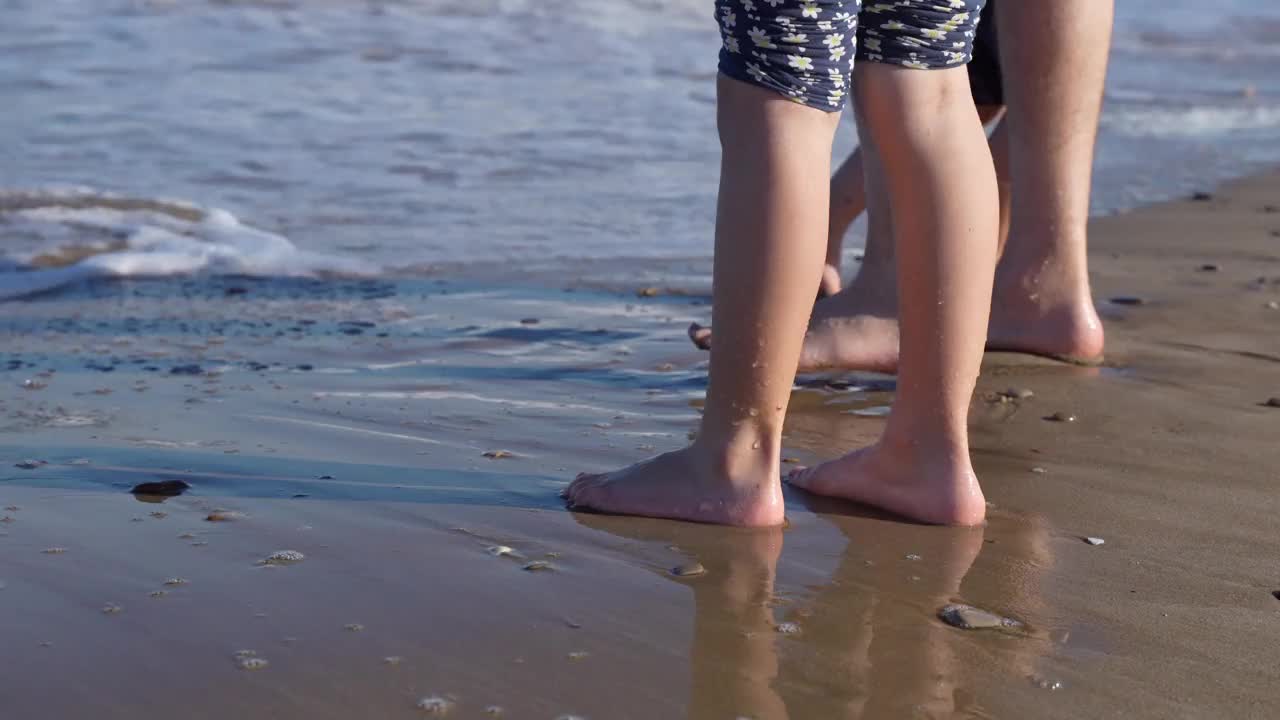 小女孩们在海边把脚弄湿视频素材