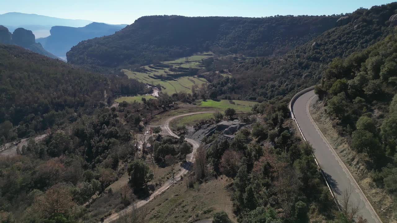 蜿蜒的道路穿过葱郁的绿色山谷和树木繁茂的山丘视频素材