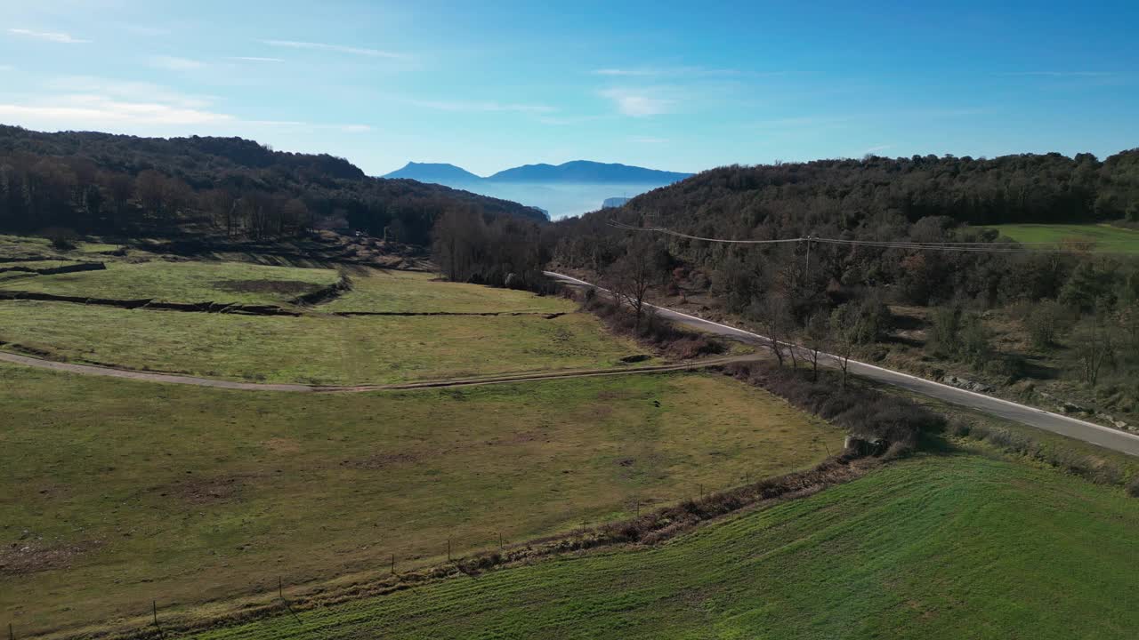 tavertet地区的绿色田野和蜿蜒的道路与远处的山脉，鸟瞰图视频素材