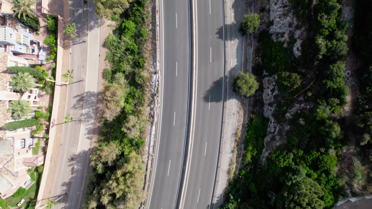 体验一个繁忙的俯视视图，曲折的道路包围着郁郁葱葱的绿色植物。·卡萨雷斯马拉加视频下载