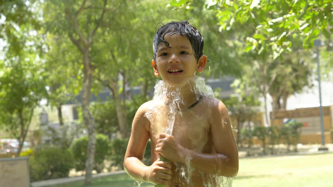 小男孩在院子里玩水视频素材