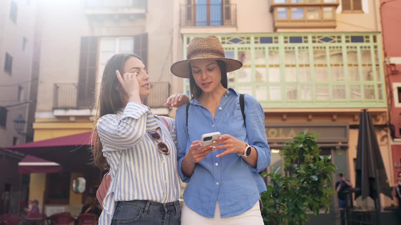 西班牙帕尔马德马略卡岛，两个女性朋友在电话上查看方向视频素材